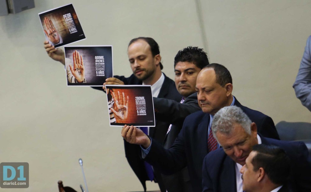 Al finalizar el discurso, diputados suplentes de ARENA protestaron con carteles en la sesión solemne donde el presidente ofreció su discurso. Foto D1: Nelson Dueñas