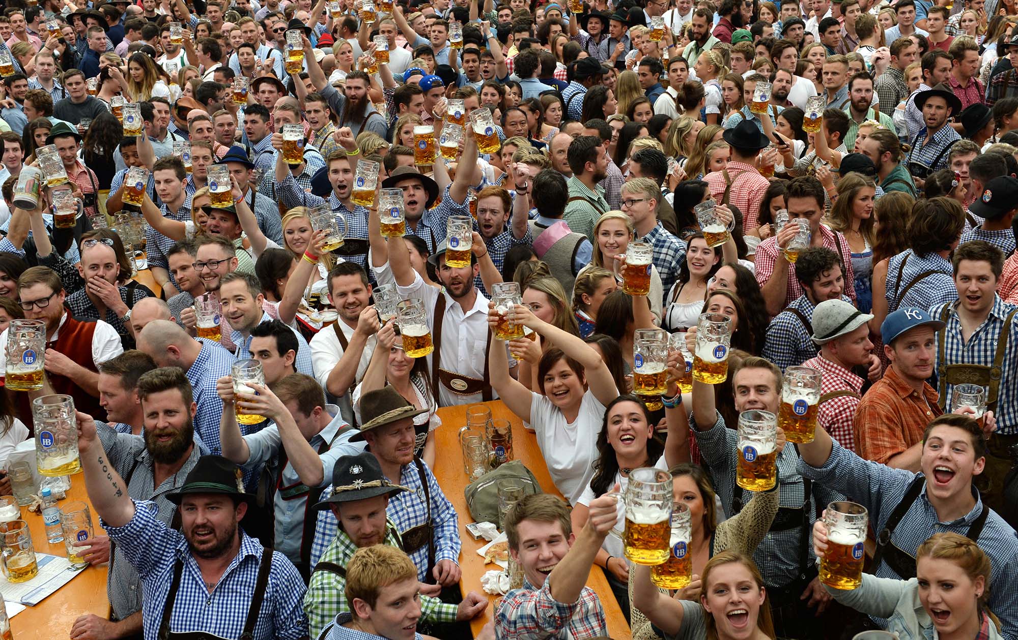 Visitantes de la fiesta de la cerveza Oktoberfest, levantan sus