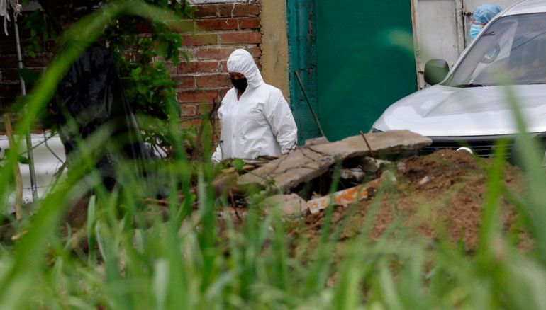 Forenses trabajan en la recuperación de cadáveres de la vivienda de Hugo Ernesto Osorio Chávez en Chalchuapa, Santa Ana. FOTO: EFE/RODRIGO SURA
