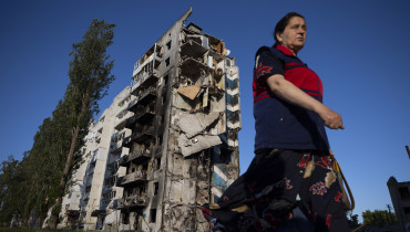 AME6464. BORODYANKA (UCRANIA), 14/06/22.- Una mujer camina hoy cerca a un edificio destruido por los bombardeos rusos, en Borodyanka (Ucrania). EFE/Orlando Barría