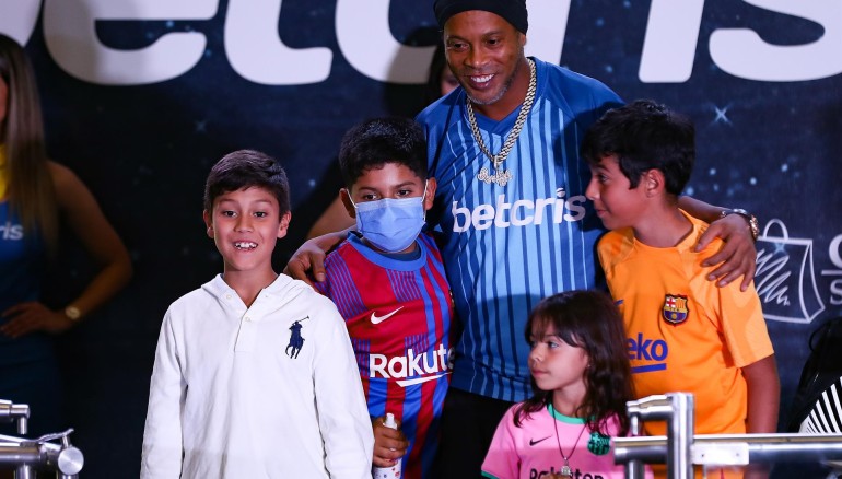 El ex futbolista brasileño Ronaldinho Gaúcho posa con niños en un concurso de fútbol-tenis y de habilidades dedicado a su figura, hoy, en un concurrido centro comercial de Quito (Ecuador). EFE