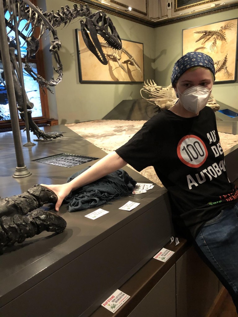 Una activista pega su mano a un fósil de dinosaurio expuesto en el Museo de Historia Nacional de Viena (Austria) este jueves para denunciar la inacción política contra la crisis climática y el uso de combustibles fósiles. EFE/Letzte Generation Österreich