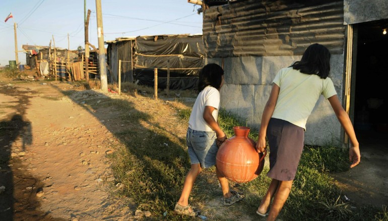En El Salvador, al menos el 68 % de su agua superficial está contaminada y unas 500.000 personas (de más de 6 millones de habitantes) no tienen agua potable. En la imagen un registro de archivo de un par de mujeres al cargar un cántaro de agua hasta su casa que no cuenta con este servicio público, en Soyapango (El Salvador). EFE/Roberto Escobar