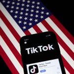 Fotografía de archivo que muestra la aplicación TikTok en la pantalla de un teléfono celular, con la bandera estadounidense de fondo. EFE/Roman Pilipey
