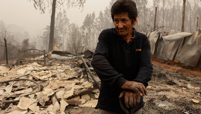 -FOTODELDÍA- AME1933. SANTA JUANA (CHILE), 05/02/2023.- Un hombre se posa sobre escombros y destrozos ocasionados por un incendio hoy, en Santa Juana, Región del Biobío (Chile). Más de 800 personas se han quedado sin hogar en Chile a causa de los incendios forestales que desde hace tres días azotan cuatro regiones del centro de Chile, con las llamas avanzando todavía sin freno desde los cerros hacia el mar en la región de Biobío, una de las más afectadas por el fuego. EFE/ Esteban Paredes Drake