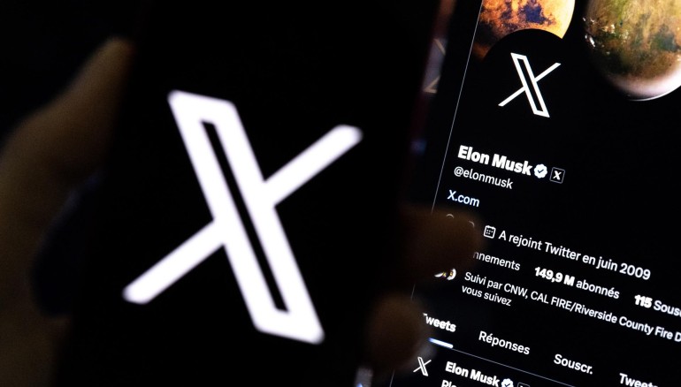 Vista de un usuario sosteniendo un teléfono móvil que muestra el logotipo 'X' frente a la página de Elon Musk en Los Ángeles, en una fotografía de archivo. EFE/EPA/ETIENNE LAURENT