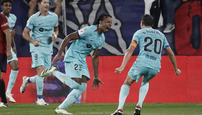 El defensa francés del FC Barcelona Jules Koundé (i) celebra su gol, primero de su equipo, durante el encuentro correspondiente a la cuarta jornada de primera división en el estadio de El Sadar, en Pamplona. EFE/ Jesús Diges