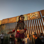 MEX1192. TIJUANA (MÉXICO), 06/11/2023.- Las marioneta Amal a su llegada hoy, en el muro fronterizo en Playas de Tijuana (México). La pequeña Amal, marioneta que representa a una niña siria refugiada de 10 años, arribo este lunes a la ciudad mexicana de Tijuana, fronteriza con Estados Unidos, para compartir un mensaje de esperanza con la población de migrantes y refugiados que se encuentran en la ciudad a la espera de asilo y protección por parte de EE.UU. EFE/ Joebeth Terríquez