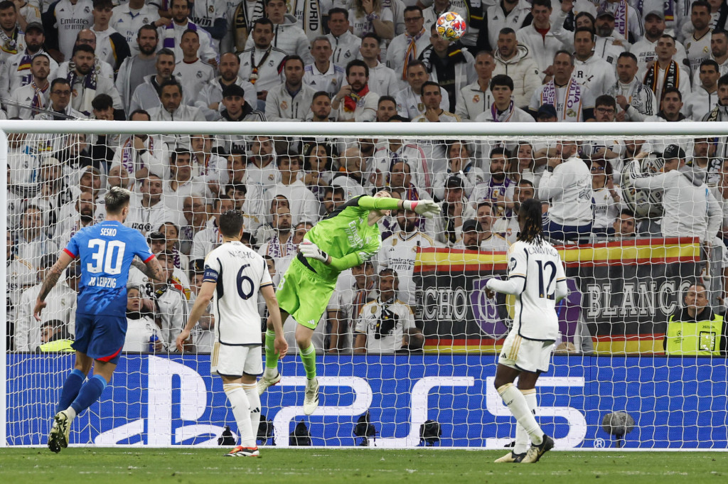 El guardameta ucraniano del Real Madrid Andriy Lunin (2d) despeja un balón en el partido de vuelta de los octavos de final de la Liga de Campeones en el estadio Santiago Bernabéu. EFE/J.J Guillén