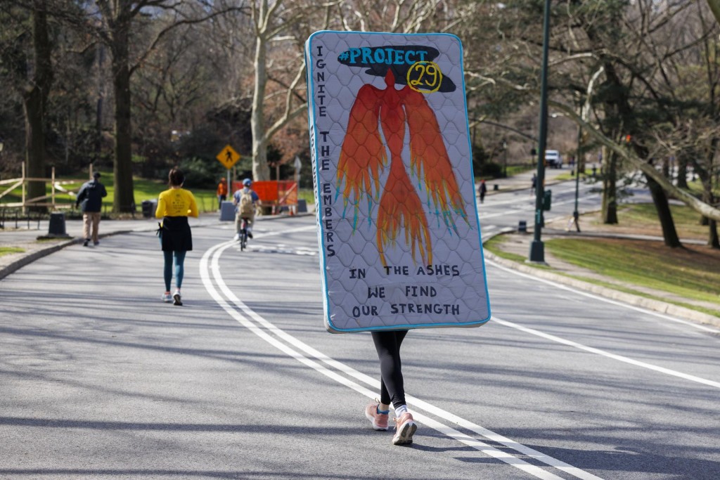 Detalle del colchón que Summer Willis (c), fundadora de la organización sin ánimo de lucro Strength Through Strides ('Fuerza a través de los pasos), llevó a sus espaldas este viernes, 8 de marzo, al recorrer en Central Park, mientras intentaba batir el récord mundial de correr un maratón con este objeto a cuestas, en el que se lee: "in the ashes we find our strengeht" (en las cenizas encontramos nuestra fuerza), para crear conciencia y recaudar fondos que ayuden a las víctimas de agresión sexual, durante el Día Internacional de la Mujer, en Nueva York (NY, EE.UU.). EFE/Sarah Yenesel