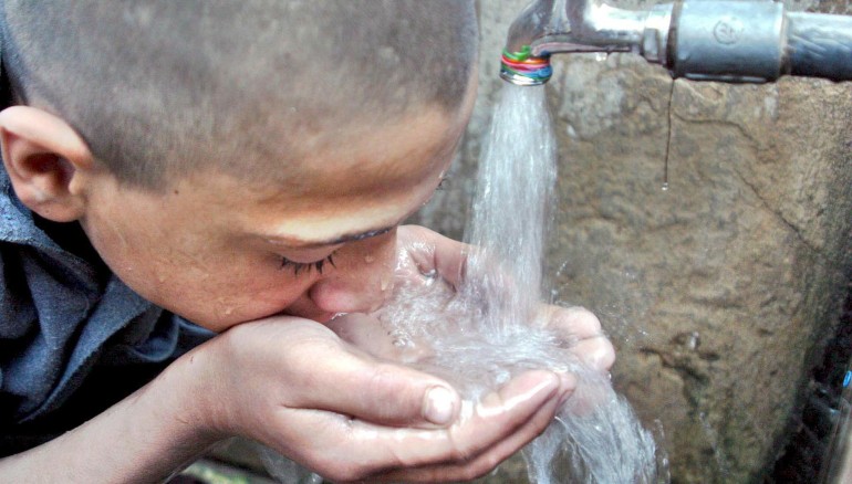 En la imagen de archivo, un niño bebe agua en un grifo comunitario en Peshawar, Pakistán. EFE/Arshad Arbab