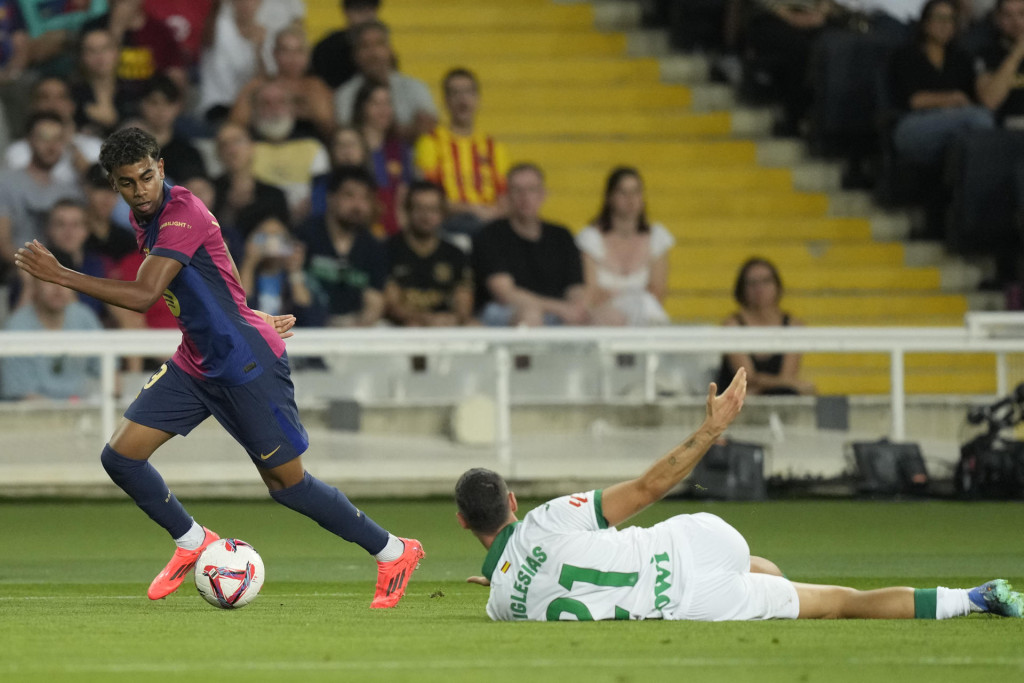 El delantero del FC Barcelona Lamine Yamal (i) se escapa de Juan Antonio Iglesias, del Getafe, durante el encuentro correspondiente a la séptima jornada de Laliga EA Sports que disputaron FC Barcelona y Getafe CF, este miércoles en el Estadi Olimpic Lluis Companys, en Barcelona. EFE/Enric Fontcuberta