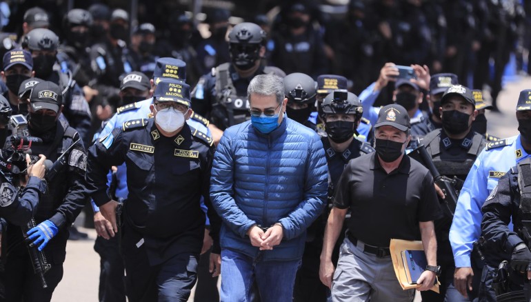 Policías custodian al expresidente hondureño Juan Orlando Hernández (c) rumbo a su extradición en la sede de la Dirección Nacional Fuerzas Especiales, en Tegucigalpa (Honduras)/Foto: EFE
